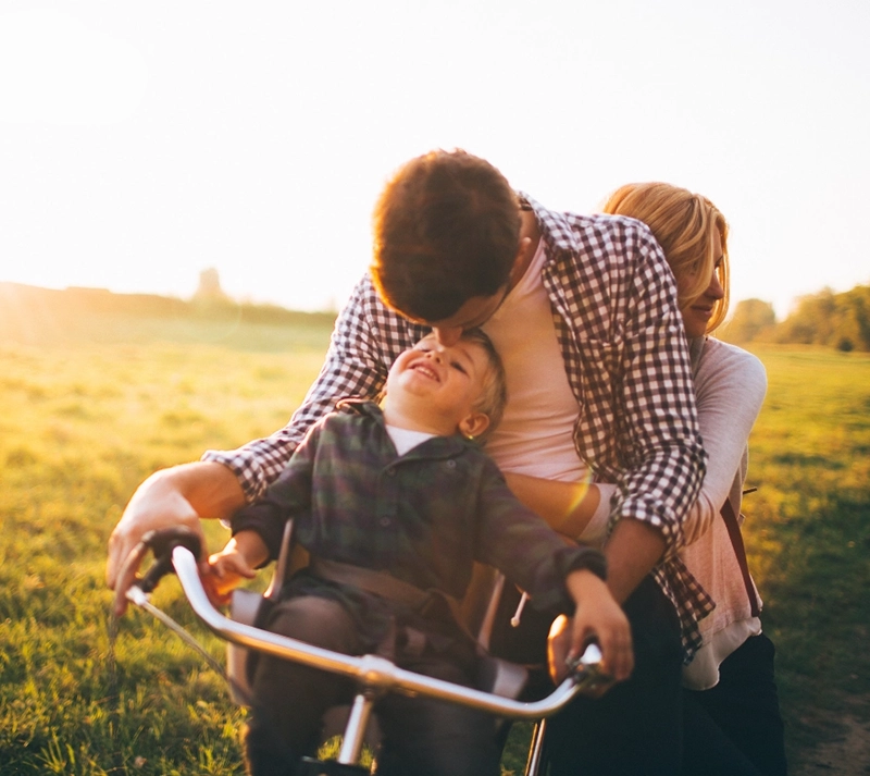 Famiglia con la bici immersi nelle campagne in un'atmosfera serena grazie alla soluzione di finanziamento Credem