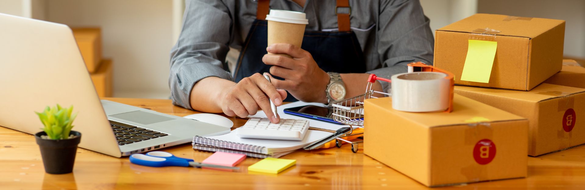 Uomo che lavora al laptop con una tazza di caffè accanto, concentrato e immerso nel suo lavoro.