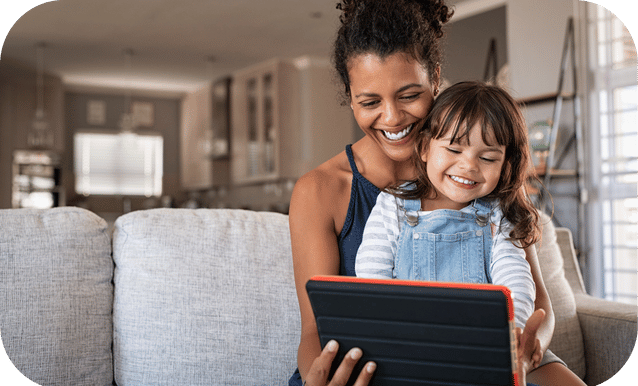 Madre e figlia che guardano l’ipad sorridenti per aver trovato BonusX, un servizio  che aiuta a capire se si può accedere ad agevolazioni fiscali.