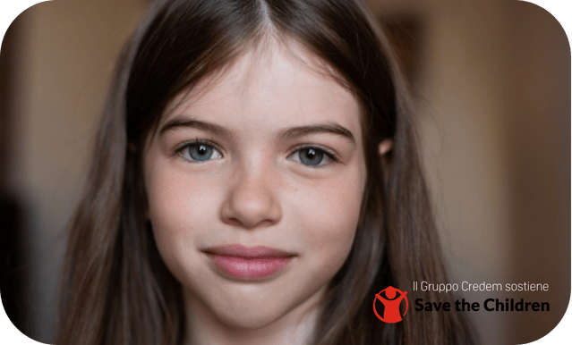 Volto di una bambina con lunghi capelli castani e occhi blu, simbolo del sostegno di Credem a Save The Children.